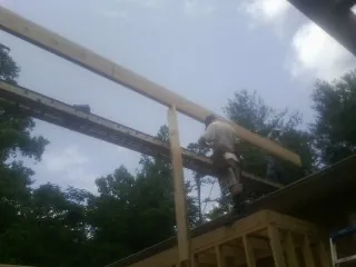 Carpenter setting a ridge beam over a new addition frame — Ice Dam Removal by Roofing Brothers in Stillwater